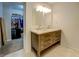 Bathroom vanity with dual sinks, wood cabinets, and a large mirror illuminated by modern lighting at 5327 David Se Cir, Covington, GA 30014
