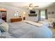 Bright main bedroom with plush carpet, ceiling fan, sitting area and tv mounted above a decorative shelf at 5327 David Se Cir, Covington, GA 30014