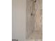 Modern shower featuring stylish vertical tiling, a rainfall showerhead, and a built-in shower caddy at 5327 David Se Cir, Covington, GA 30014