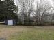 Spacious backyard featuring a shed and mature trees at 56-1 N East Main St, Hampton, GA 30228