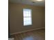 Neutral bedroom featuring a window and wood-look vinyl floors throughout at 56-1 N East Main St, Hampton, GA 30228