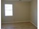 Neutral bedroom with wood-look vinyl flooring featuring a window at 56-1 N East Main St, Hampton, GA 30228