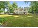 Spacious backyard featuring green grass, mature trees, and a wooden deck perfect for outdoor enjoyment at 632 Cloudland Dr, Stockbridge, GA 30281