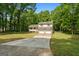 View of two-story home and a long driveway surrounded by lush green trees and foliage at 632 Cloudland Dr, Stockbridge, GA 30281