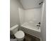 Bathroom with a white tub surround, toilet, and dark hardware at 808 Covered Bridge Rd, Covington, GA 30016