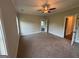 Neutral bedroom featuring ceiling fan, carpet floors, and doors leading into the closets and bathroom at 808 Covered Bridge Rd, Covington, GA 30016