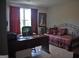 Bedroom featuring a daybed with decorative pillows, a large desk, and bright natural light at 808 Covered Bridge Rd, Covington, GA 30016