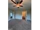 Neutral bedroom featuring ceiling fan, carpet floors, and doors leading into the closets and bathroom at 808 Covered Bridge Rd, Covington, GA 30016