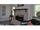 Cozy living room featuring a brick fireplace and dark hardwood floors at 808 Covered Bridge Rd, Covington, GA 30016