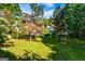 Lush green lawn with trees framing the exterior view of a brick home and the serene lake at 1295 Heritage Dr, Villa Rica, GA 30180