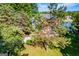 Beautiful backyard with mature trees, leading to the brick home and the serene lake beyond at 1295 Heritage Dr, Villa Rica, GA 30180
