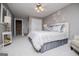 Neutral-toned bedroom with plush carpet, ceiling fan, and a decorative accent wall above the king-sized bed at 1295 Heritage Dr, Villa Rica, GA 30180