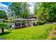 Lakefront home with boat dock featuring multiple boat slips, lush lawn, mature trees, and lovely landscaping at 1295 Heritage Dr, Villa Rica, GA 30180