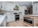 Bright kitchen boasts stainless steel appliances, white cabinets, subway tile backsplash and light wood floors at 1295 Heritage Dr, Villa Rica, GA 30180