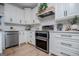 Bright kitchen boasts stainless steel appliances, white cabinets, subway tile backsplash and light wood floors at 1295 Heritage Dr, Villa Rica, GA 30180