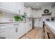 Bright kitchen features a stainless steel dishwasher and white cabinets with contrasting hardware and light wood floors at 1295 Heritage Dr, Villa Rica, GA 30180