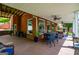 Covered back patio featuring ample seating, ceiling fans, brick wall, and views of the landscaped backyard at 1295 Heritage Dr, Villa Rica, GA 30180