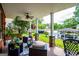 Covered back porch featuring ample seating, stone columns, ceiling fans, and views of the lake at 1295 Heritage Dr, Villa Rica, GA 30180