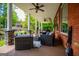 Covered back porch featuring ample seating, stone columns, brick wall, ceiling fans, and views of the lake at 1295 Heritage Dr, Villa Rica, GA 30180