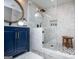 Stylish shower with subway tile and river rock flooring. Features a blue vanity with decorative mirrors at 1295 Heritage Dr, Villa Rica, GA 30180