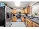 Well-lit kitchen with stainless steel appliances, oak cabinets, and white tile flooring at 502 Gallantry Trl, Mcdonough, GA 30252