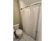 Cozy bathroom featuring a toilet, shower with a white curtain, and light-colored tile floor at 110 Kari Glen Way, Fayetteville, GA 30215