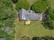 An aerial view captures the roof of the house and backyard featuring a wooden deck, grass, and surrounding trees at 105 Birch Creek Cir, Mcdonough, GA 30253