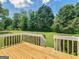 Backyard view from the wooden deck showcases lush landscaping, green grass, and mature trees for peaceful outdoor at 105 Birch Creek Cir, Mcdonough, GA 30253