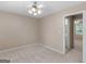 Neutral bedroom features a ceiling fan, beige carpet, and doorway to bathroom for comfortable living at 105 Birch Creek Cir, Mcdonough, GA 30253