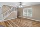 Bright room featuring hardwood floors, a ceiling fan and staircase access providing a versatile living space at 105 Birch Creek Cir, Mcdonough, GA 30253