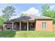 Brick home featuring a covered back patio with outdoor seating and a grill on a grassy lawn at 570 Mcgarity Dr, Mcdonough, GA 30252