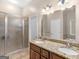 Bathroom featuring a double sink vanity, large mirror, and a glass-enclosed shower at 570 Mcgarity Dr, Mcdonough, GA 30252