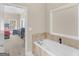 Bathroom featuring a soaking tub with jets, and a view into the main bedroom at 570 Mcgarity Dr, Mcdonough, GA 30252