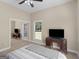 Bedroom featuring neutral tones, a ceiling fan, and a mirrored closet reflecting a dark wood TV stand at 570 Mcgarity Dr, Mcdonough, GA 30252