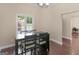Bright dining room featuring dark wood floors and a modern table set with view of the landscaped exterior at 570 Mcgarity Dr, Mcdonough, GA 30252