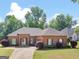 A brick home with manicured lawn and landscaping features a symmetrical façade and an attached garage at 570 Mcgarity Dr, Mcdonough, GA 30252