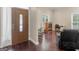 Foyer featuring rich hardwood floors and a door with decorative glass, leading into a sunny living space at 570 Mcgarity Dr, Mcdonough, GA 30252