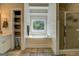 Bright bathroom featuring a soaking tub, shower, and built in storage with natural light from a window with wooded views at 857 Cooper Rd, Social Circle, GA 30025