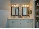 Bathroom vanity featuring double sinks, framed mirrors, white cabinetry, and ample counter space at 857 Cooper Rd, Social Circle, GA 30025