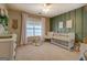 Charming Bedroom with a white crib, soft decor, and a green accent wall at 857 Cooper Rd, Social Circle, GA 30025
