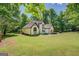 Charming white brick home with black trim and wood shutters with a large yard at 857 Cooper Rd, Social Circle, GA 30025