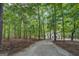 Exterior view of a home situated at the end of a gravel driveway surrounded by mature trees at 857 Cooper Rd, Social Circle, GA 30025