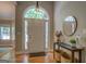 Inviting foyer with hardwood floors, and a decorative table with a round mirror at 857 Cooper Rd, Social Circle, GA 30025