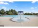 Community pool featuring a fountain surrounded by chairs and manicured greenery under a bright, partly cloudy blue sky at 1841 N Lacebark Elm Way # 101, Lawrenceville, GA 30045