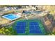 Aerial view of community tennis courts, pool, and playground, nestled among mature trees and homes at 1841 N Lacebark Elm Way # 101, Lawrenceville, GA 30045