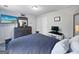 Comfortable bedroom featuring a queen-size bed, two windows, and a dresser with a mounted TV at 715 Frog Rd, Locust Grove, GA 30248
