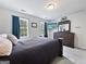 Comfortable bedroom featuring a queen-size bed, two windows, and a dresser with a mounted TV at 715 Frog Rd, Locust Grove, GA 30248