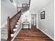 Inviting foyer with hardwood floors, staircase with wood banister and gray walls at 715 Frog Rd, Locust Grove, GA 30248