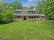 Charming two-story home with a welcoming porch, lush lawn, and surrounded by mature trees at 715 Frog Rd, Locust Grove, GA 30248
