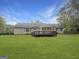 Expansive backyard featuring a spacious deck, mature trees and well-maintained lawn at 401 Grove Pointe Ct, Locust Grove, GA 30248